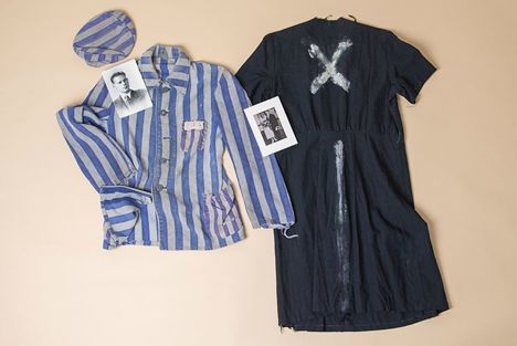 Holocaust-era garments and photographs, including a striped prisoner uniform and a dark dress marked with white X symbols
